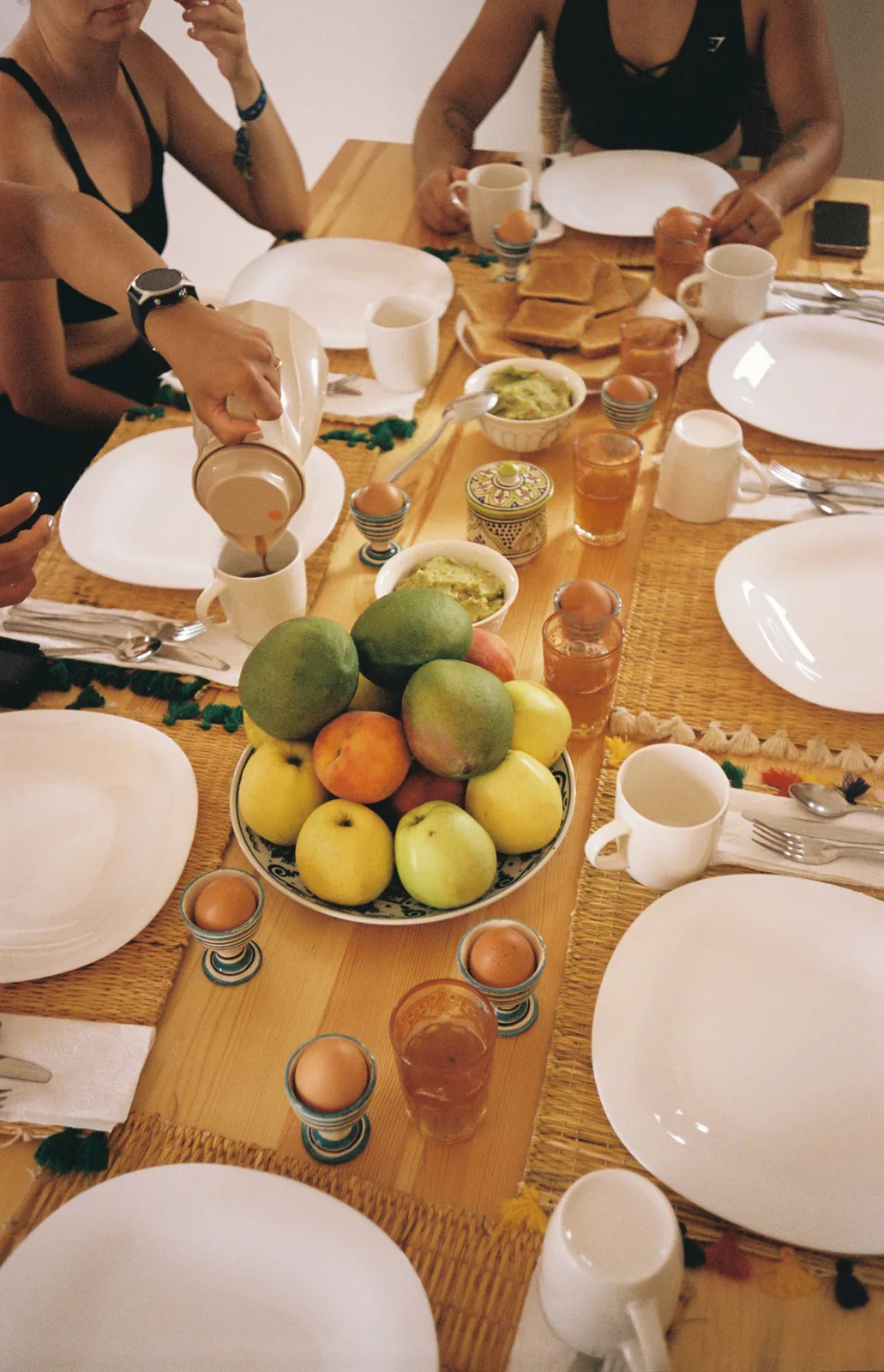 Breakfast table with fruit, eggs, toast and mint tea