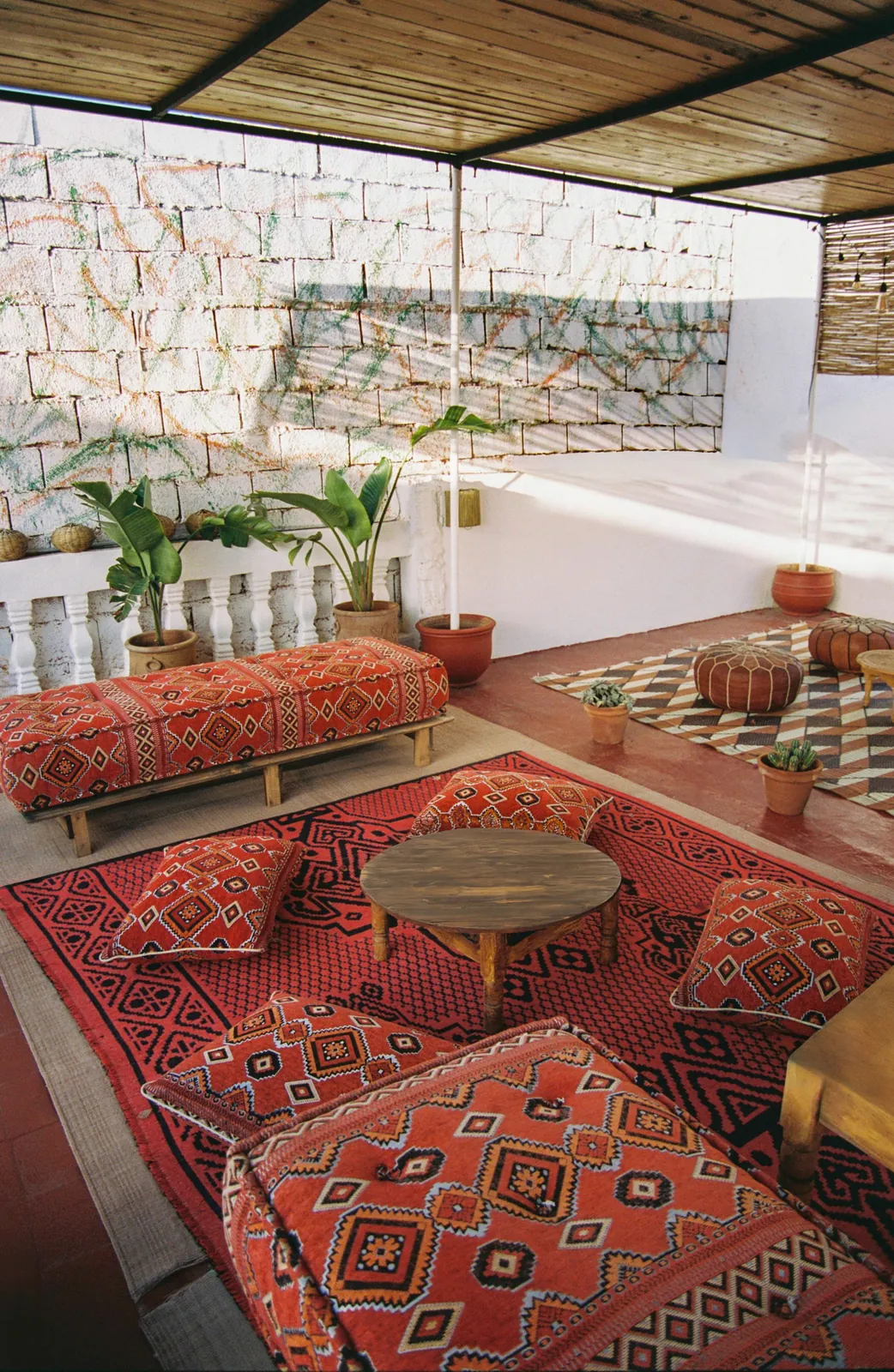 Rooftop lounge at the camp with red Amazigh cushions