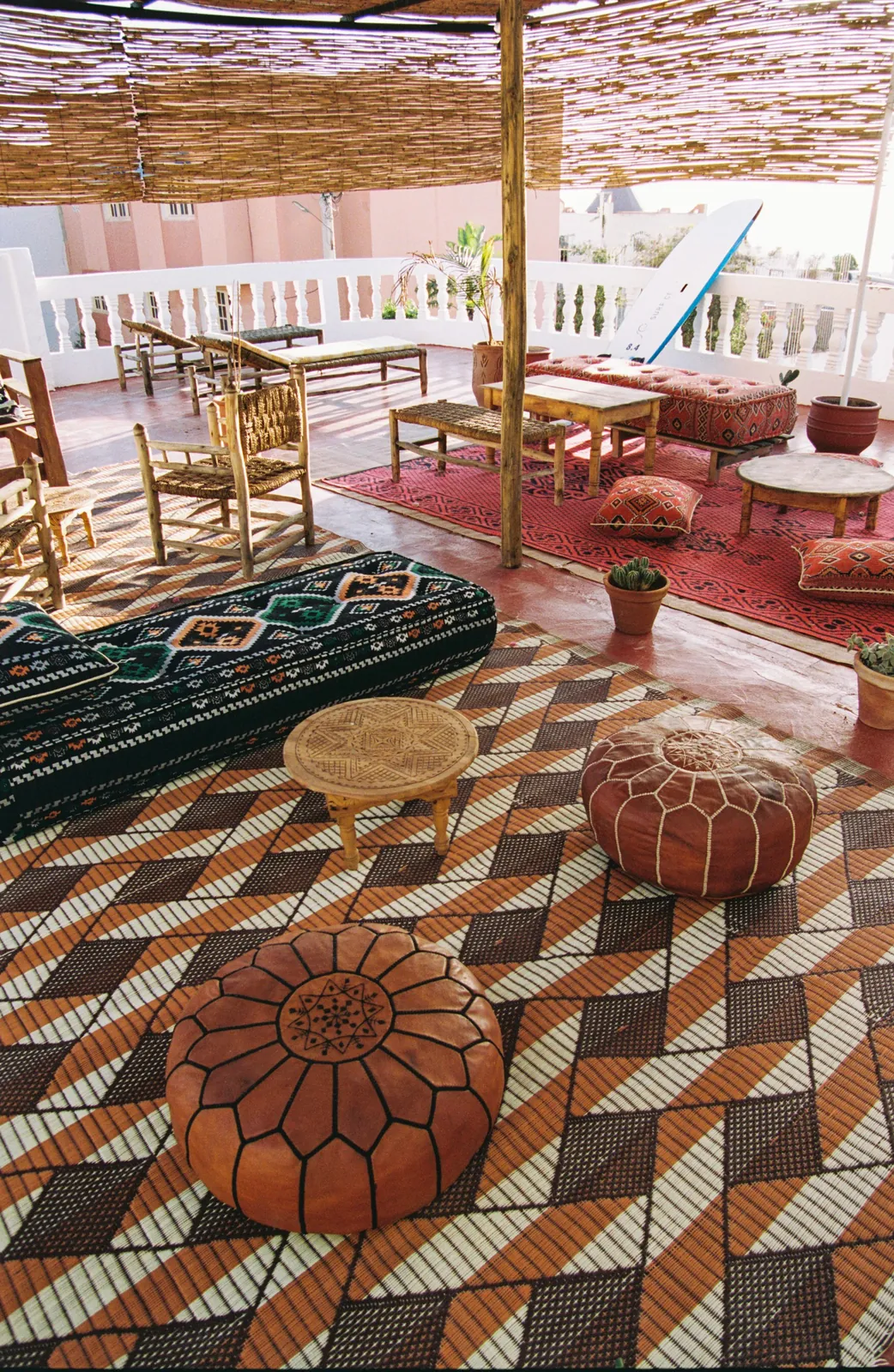 Leather poufs and woven rugs on the rooftop