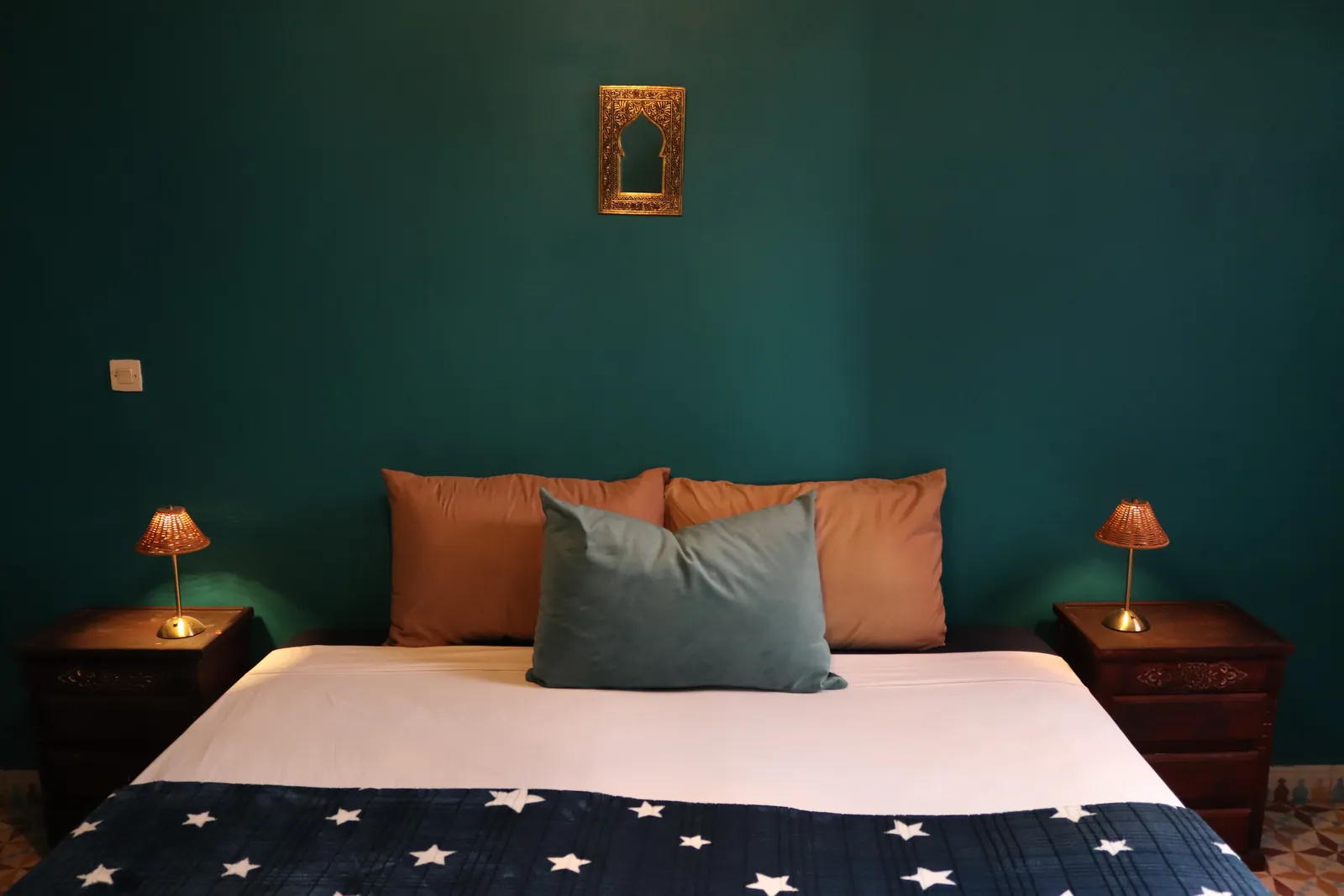 Olive Green Room with a double bed, brass lamps and a Moroccan mirror