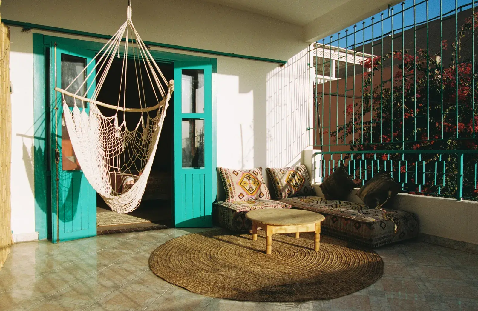 Private terrace with a hanging chair and turquoise doors
