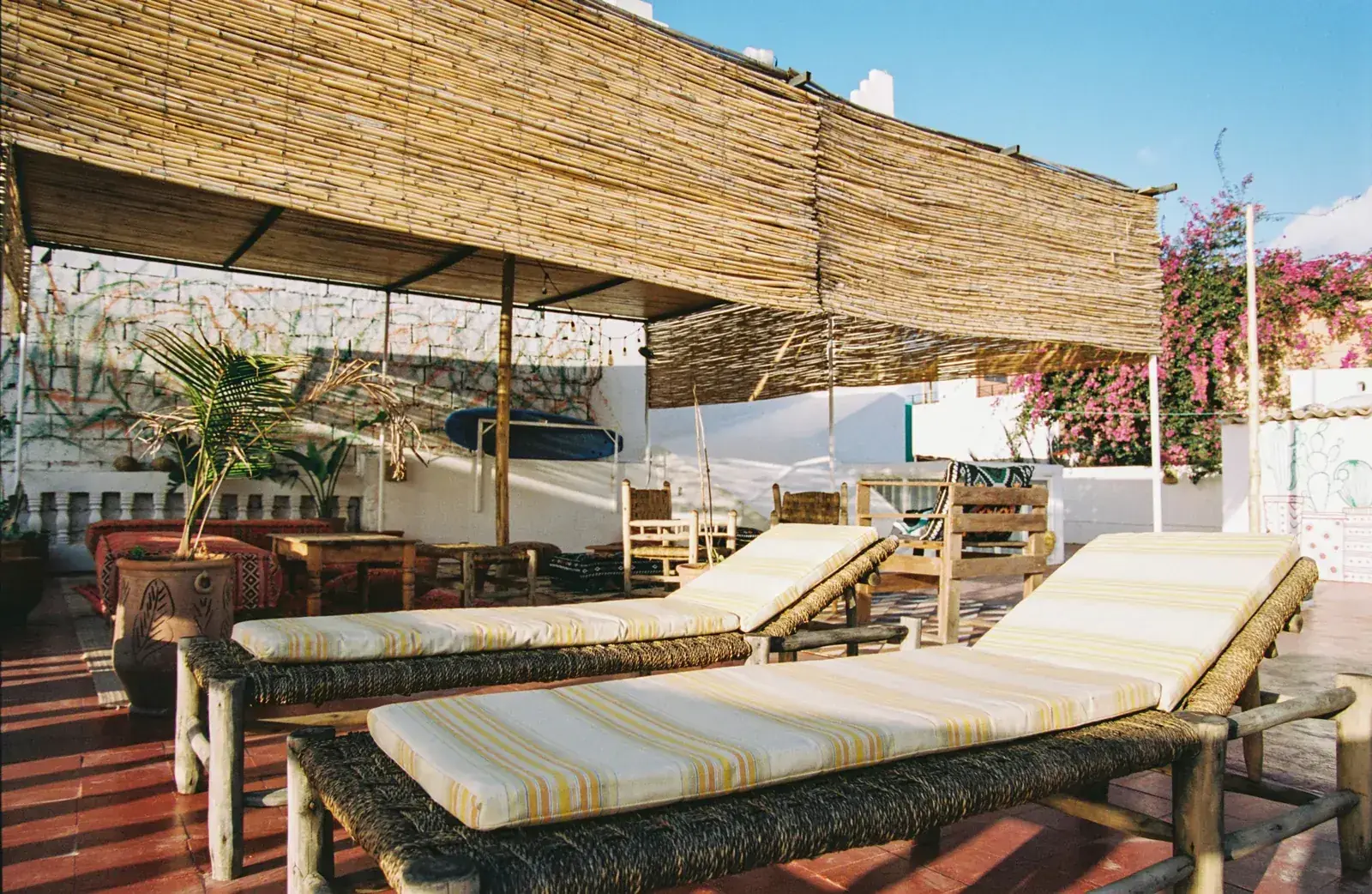 Sun loungers on the rooftop under a reed shade
