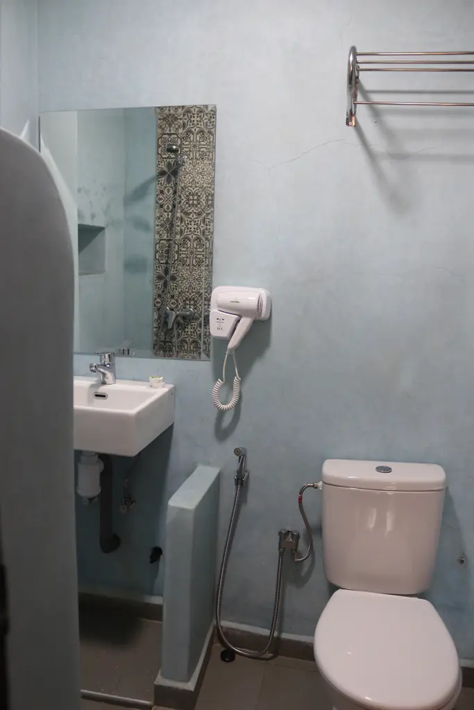 Blauwe tadelakt-badkamer met wastafel en föhn