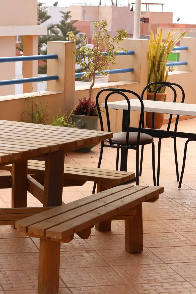 Houten picknicktafel en bistrostoelen op het dak