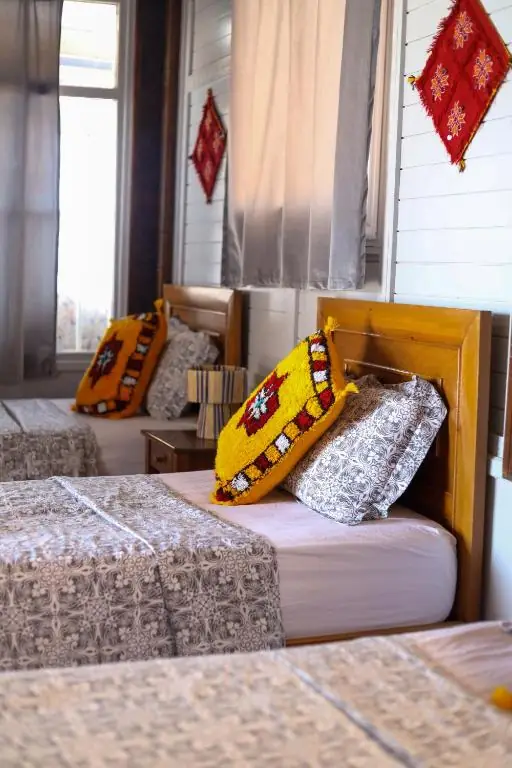 Single bed with an orange cushion