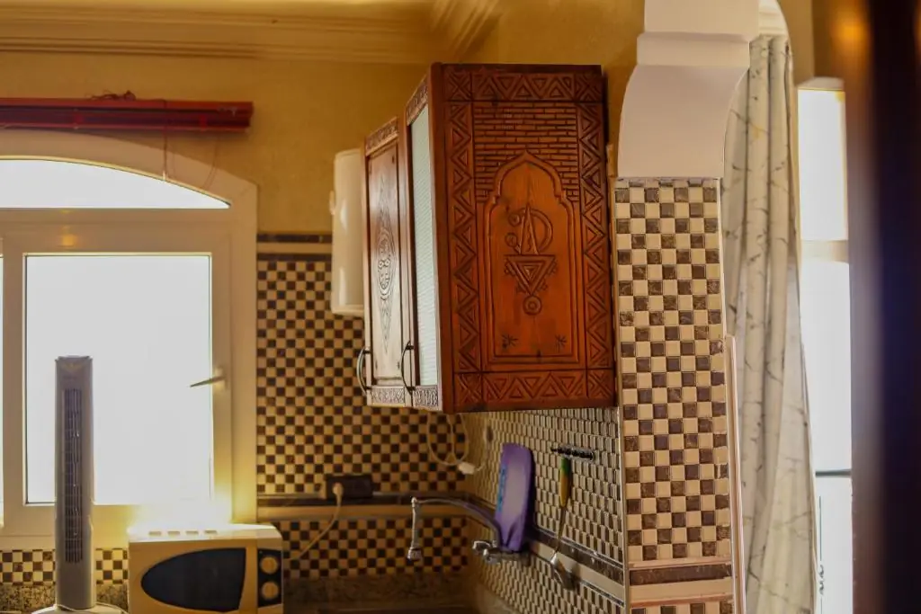 Zellige kitchenette with carved wood cupboards