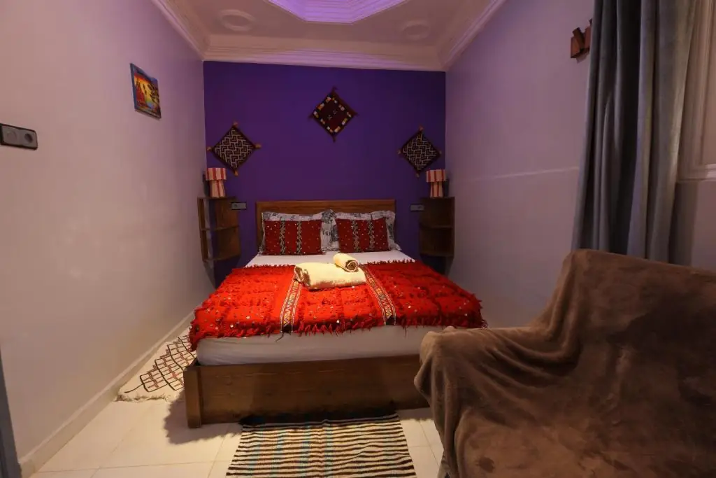 Double bed and sofa in the purple room