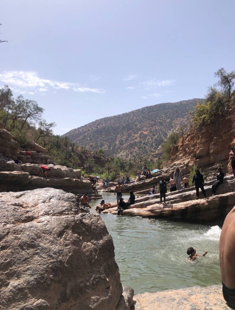 Viajeros nadando en una piscina de montaña clara rodeada de rocas de cañón