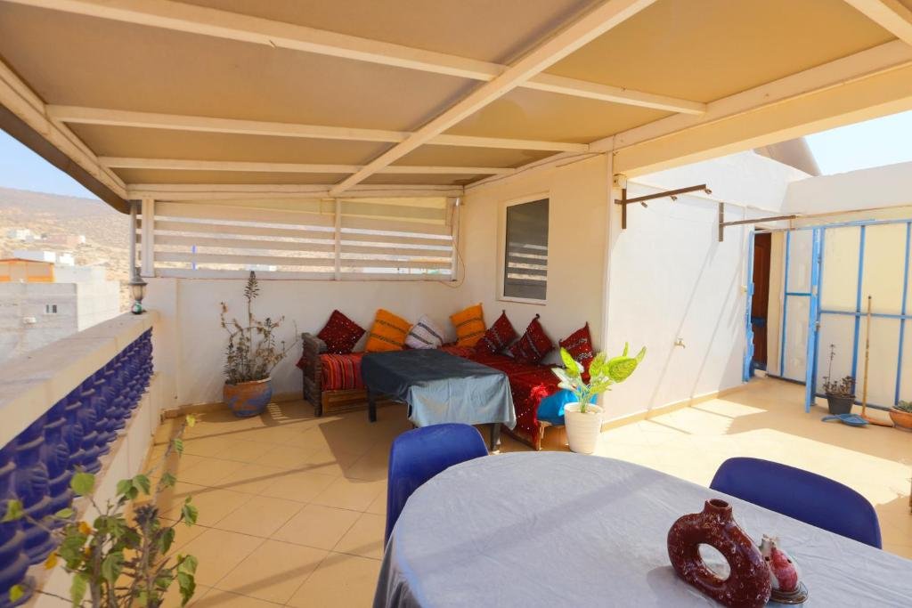 Portátil y café en la azotea de un riad con vistas al océano Atlántico en Tamraght